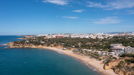 Fototapeta premium Aerial photo of the beautiful town in Albufeira in Portugal showing the Praia da Oura golden sandy beach, with hotels and apartment in the town, taken on a summers day in the summer time.