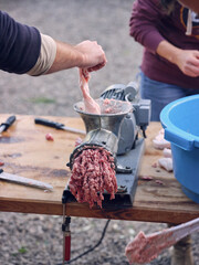 Crop people making beef mince using grinder