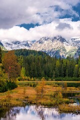 Beautiful mountain lake with a reflection of autum park on water and high peaks in the Background. The new Strbske pleso lake in High Tatras mountains in Slovakia.