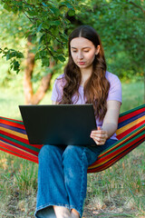 work in nature with laptop.woman with computer in nature.online work from home.online training.business lady.chat and communication.girl communicates with laptop.work from home.freelancer.on a hammock