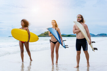 Group Friendship playing surfboard on the beach in weekend activity, Sport extreme healthy lifestyle concept.