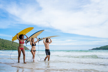 Group Friendship playing surfboard on the beach in weekend activity, Sport extreme healthy...