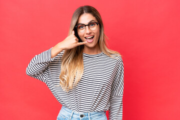 Young Uruguayan woman isolated on red background making phone gesture. Call me back sign