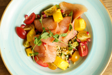 Tabbouleh salad with mango, colorful tomatoes and smoked salmon