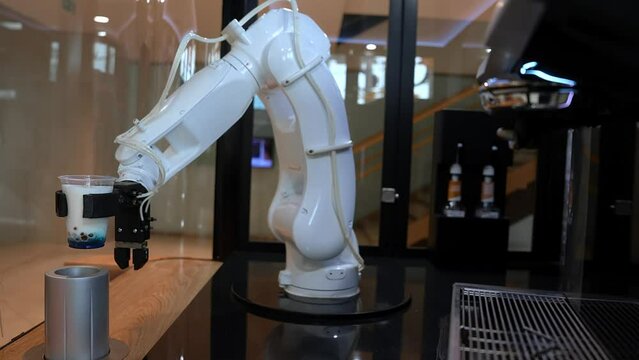 Automatic robot arm preparing coffee with coffee machine. Robot barista making coffee in a coffee shop.