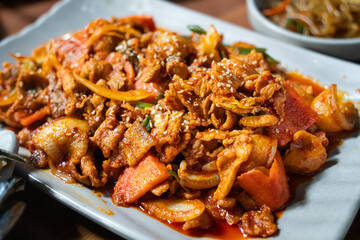 Delicious Korean cuisine jeyuk bokkeum, stir-fried pork in a plate for serving dish.
