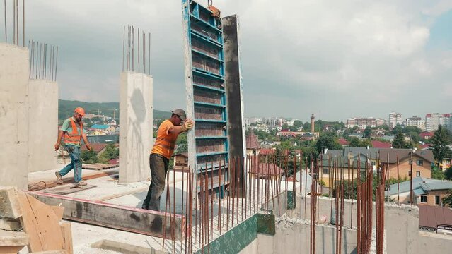 The builder works on the construction site. Installation of metal structures for filling with a monolith. Builder without helmet and reflective vest.