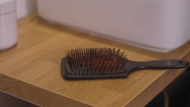 Woman putting comb on night table, close up view