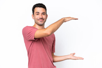 Young handsome man over isolated white background holding copyspace to insert an ad