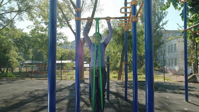 Novice Female Athlete Uses A Rubber Band To Pull Ups