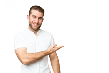 Young handsome blonde man over isolated chroma key background presenting an idea while looking smiling towards