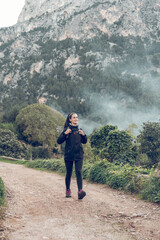 Woman on road while hiking in mountainous valley