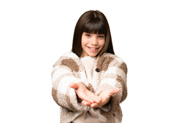 Little girl over isolated green chroma key background holding copyspace imaginary on the palm to...