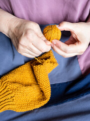 front view of women's hands unravel knitted sweater close up