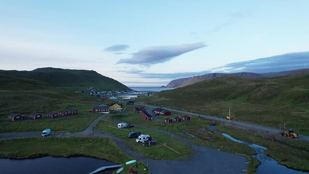 Aerial shot of a fishing village in the north cape with a fjord and mountains and background, Skarsvag, Norway