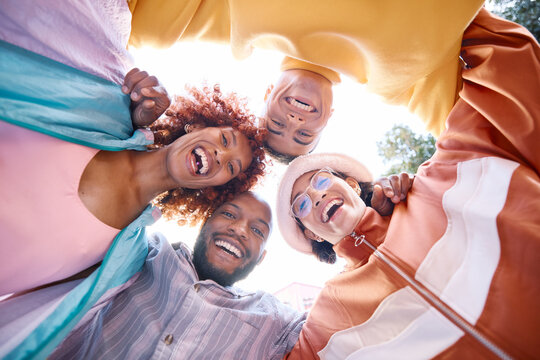 Portrait, smile and a group of friends in a huddle outdoor together for freedom, bonding or fun from below. Diversity, travel or summer flare with happy men and women laughing outside on vacation