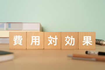 費用対効果と書かれたブロックが置かれたデスク