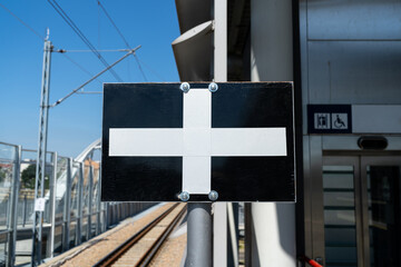 W4 stop indicator railway sign plate. White cross on a black rectangular background. Signboard...