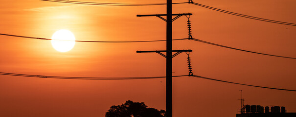 High voltage electric transmission pylon. High voltage power lines against sunset sky. Electricity...