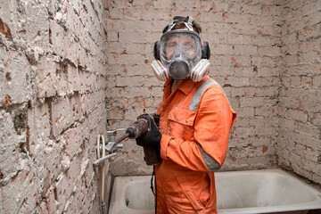 Builder wearing full face respirator mask and ear defenders for working in dusty and noisy...