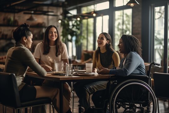 Diverse female colleagues in discussion at casual office meeting. Casual office, teamwork, disability, inclusivity, business and work.