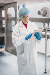 Fototapeta premium Supervisors check automated bottling for sequence accuracy, safety, reliability at water pipeline.
