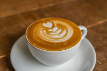 beautiful patterned milk coffee in a white cup