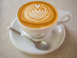 beautiful patterned milk coffee in a white cup
