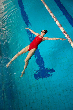 Experienced female athlete doing starfish float in swimming pool