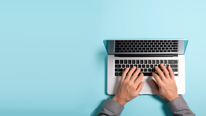 Fototapeta premium Top view of businessman typing on laptop on workplace, copy space