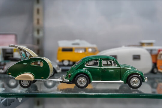 Toy or model  green Volkswagen bug with camping trailer on display,