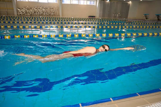 Young athlete practicing front crawl stroke in water