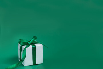 the gift is white with a green ribbon on a green background