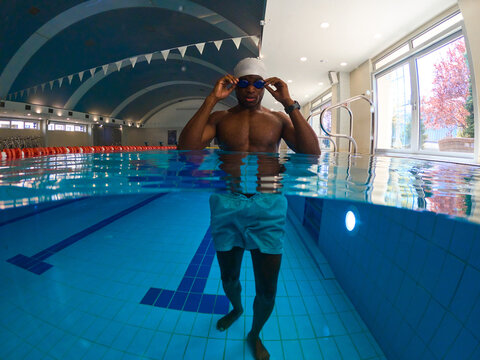 Confident swimmer getting ready to swim in sports pool