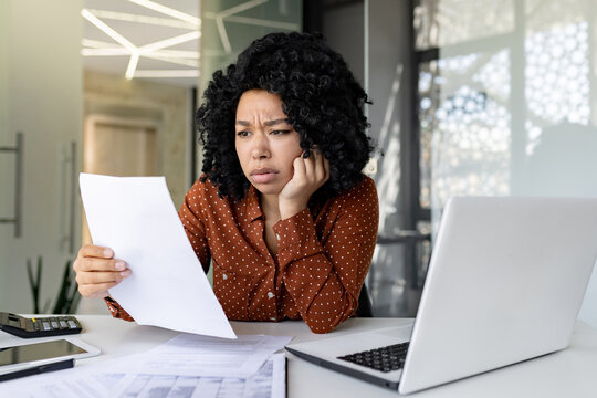 Upset and unsatisfied woman at workplace, businesswoman boss checking documents, accounts and contracts, financial woman got bad results in financial reports, working inside office with laptop.