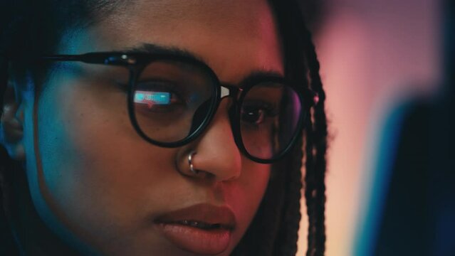 African American woman in glasses checking social media likes and follows in app