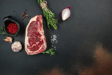 Raw New York steak on a dark background. banner, menu, recipe place for text, top view