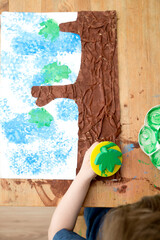 Kid draws a gouache spring tree. Children activities, easy ideas at home. Art lessons spring theme. DIY tasks for children. Early education.
