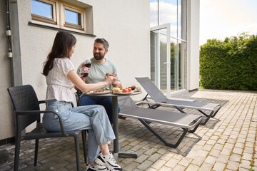 Nice middle-aged couple is located with food and wine at their cottage