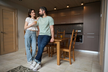 Caucasian man and woman communicate cutely at home in kitchen