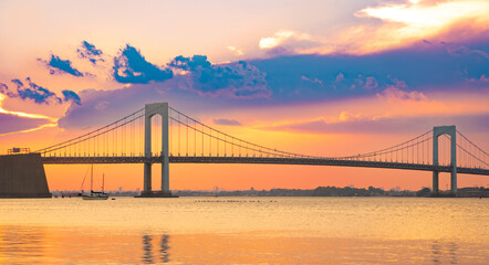 Beautiful view of the Throgs Neck Bridge seen from Bayside Queens looking towards the Bronx, New York City seen during colorful sunset.