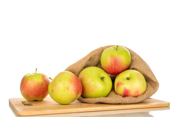Several sweet juicy apples in a jute bag and on a bamboo kitchen board, macro, isolated on white background.