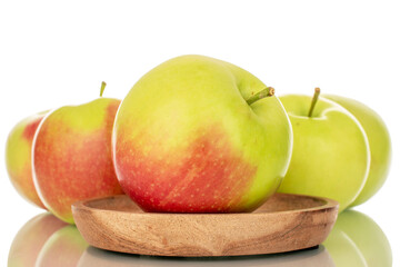 Several sweet juicy apples on a wooden plate, macro, isolated on white background.