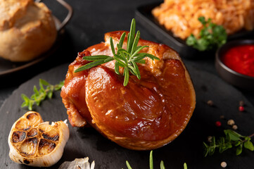 Delicious Smoked pork knuckle in a crispy crust. Tender and juicy pork wrapped in crispy.  Festive table with delicious food on slate boards. Roasted Pork leg, German food, Eisbein.