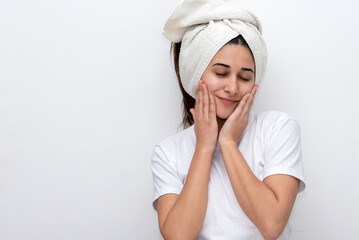 young latin woman with white towel on her head white t-shirt and white background gesturing...