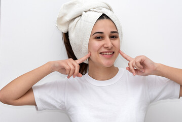 young latin woman with white towel on her head white t-shirt and white background gesturing happiness