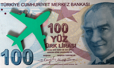 Banknote of 100 Turkish lira and a symbolic passenger plane