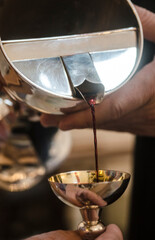 Altar wine poured into an altar silver cup by the priest