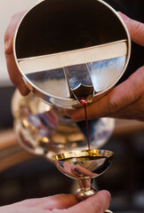 Altar wine poured into an altar silver cup by the priest