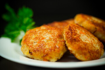 Cooked fried fish cutlets in a plate with herbs.